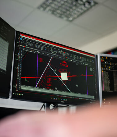 Expert Cteam analysant des sch&eacute;mas techniques complexes et des donn&eacute;es sur des moniteurs.